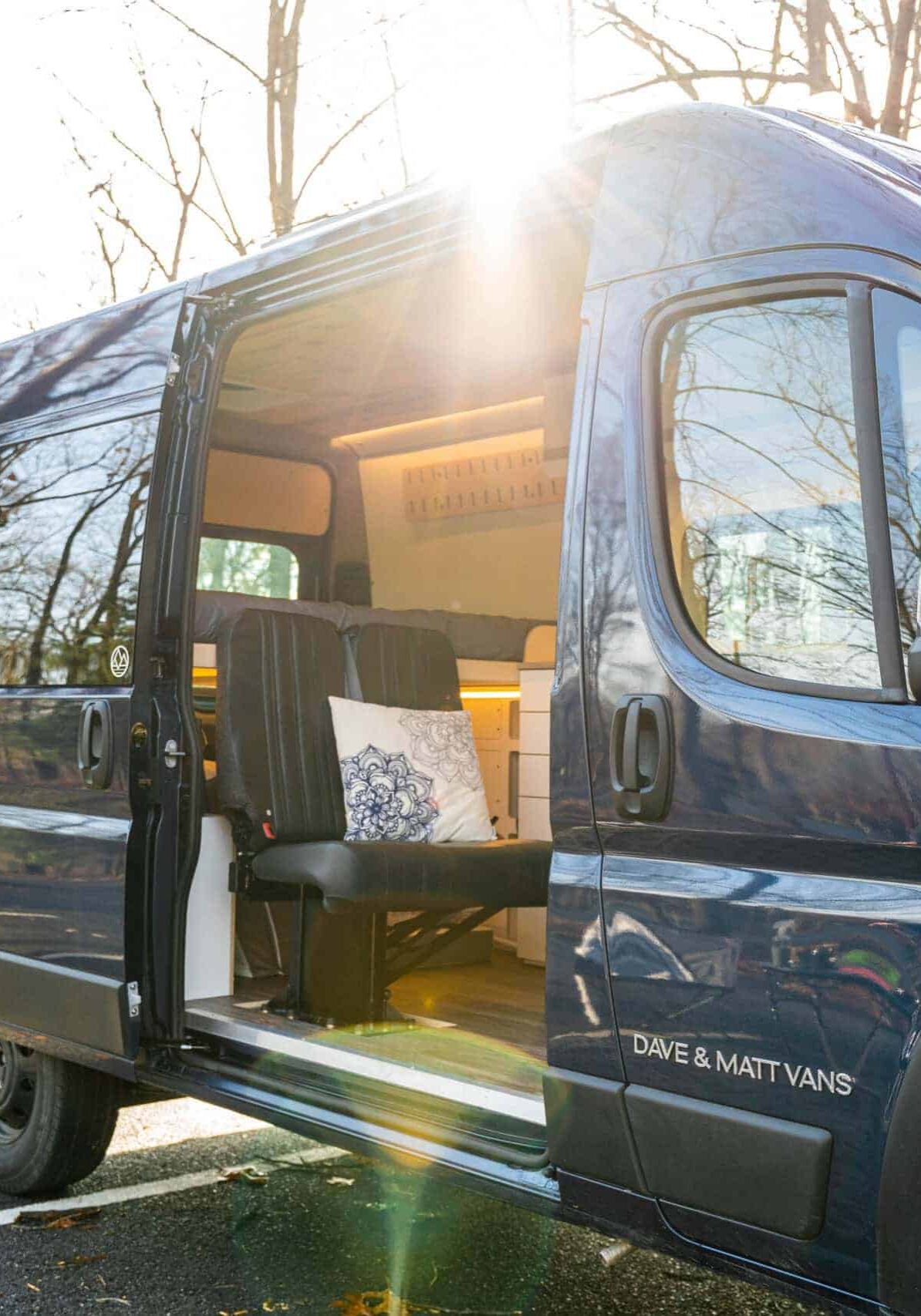 High roof blue campervan camping in an autumnal campsite.